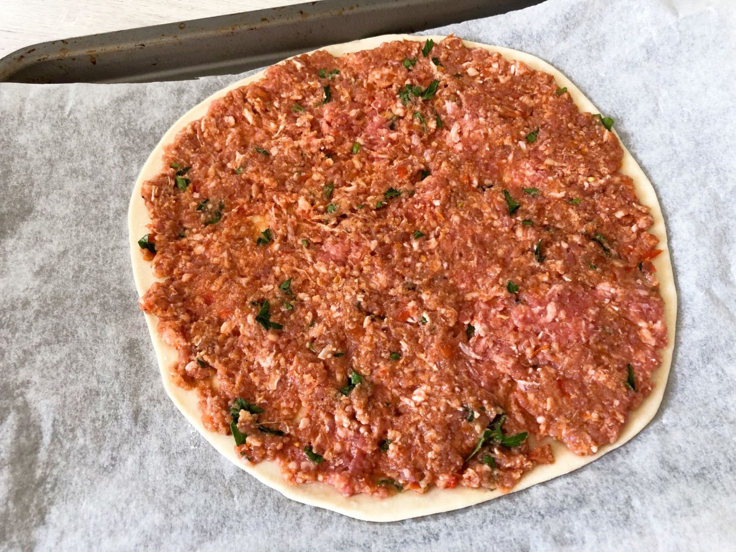 Lahmacun dough covered in spicy lamb meat